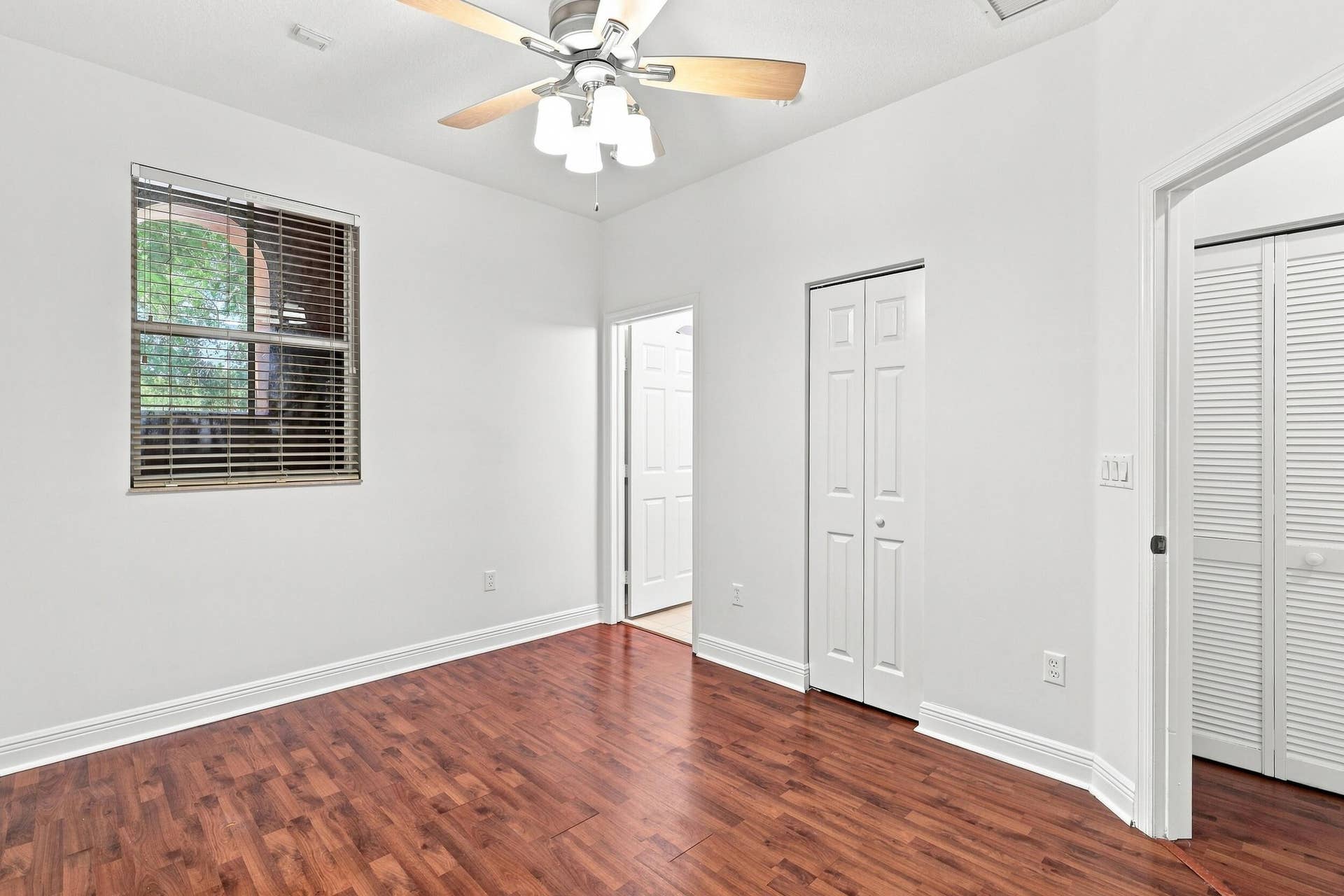 2107 Anchor Court, Fort Lauderdale, FL 33312 Spacious guest bedroom with wood flooring, ceiling fan, generous closet space, natural light, and a private ensuite full bathroom.