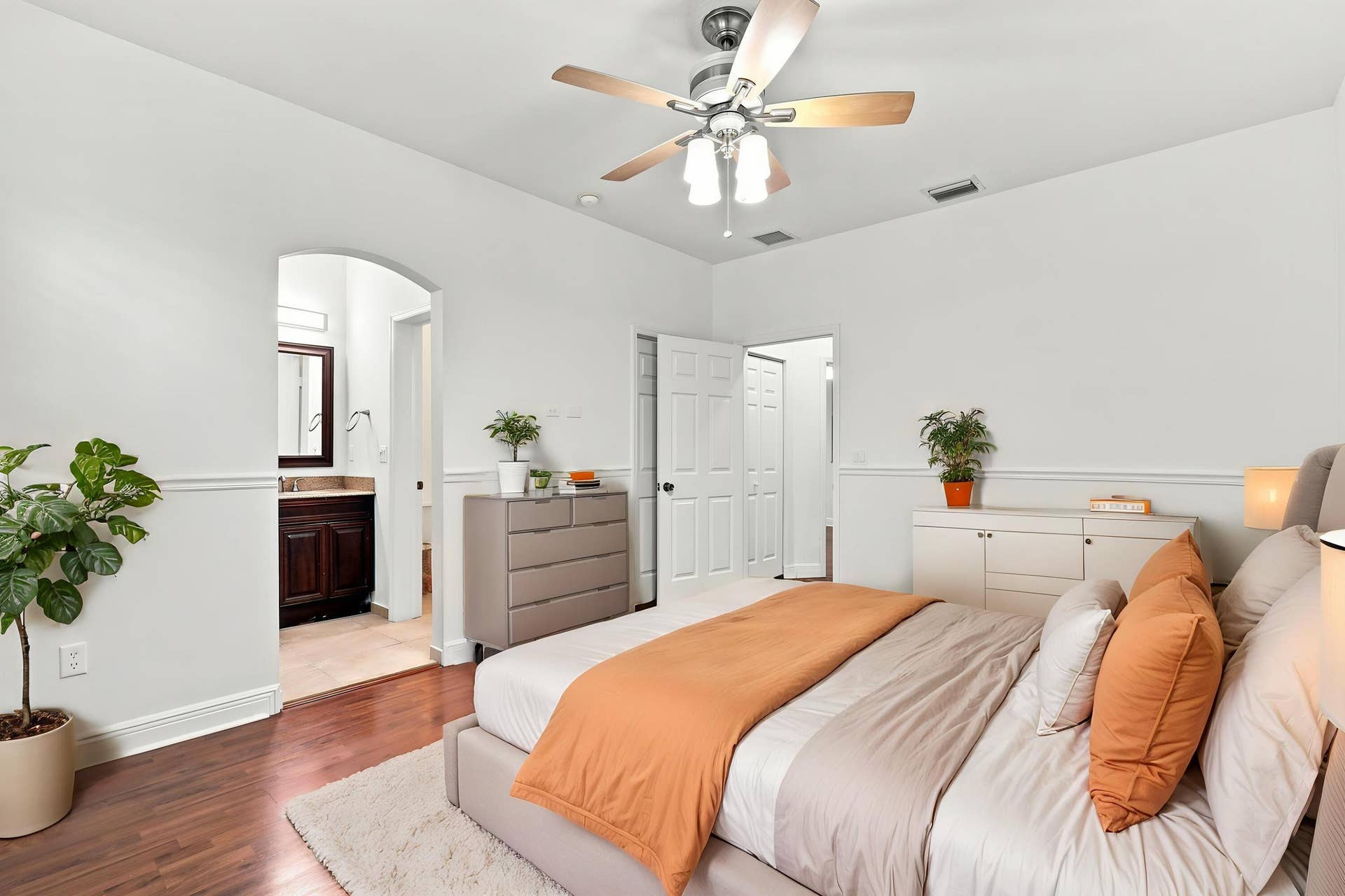 2107 Anchor Court, Fort Lauderdale, FL 33312 Spacious primary suite featuring warm wood flooring, abundant natural light, a large window overlooking lush greenery, and direct access to the private ensuite bathroom. The generous layout provides plenty of space and creates a comfortable private retreat.