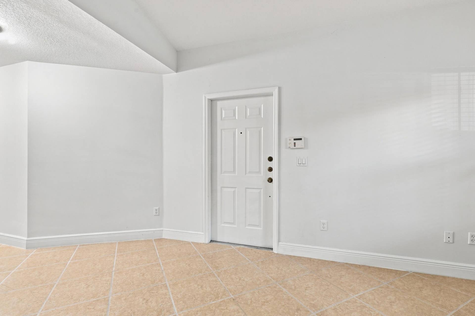 2107 Anchor Court, Fort Lauderdale, FL 33312 Spacious living area just off the front entry featuring tile flooring, high ceilings, and an open layout that flows seamlessly toward the kitchen and dining areas. A wood staircase adds warmth and character while leading to the second floor.