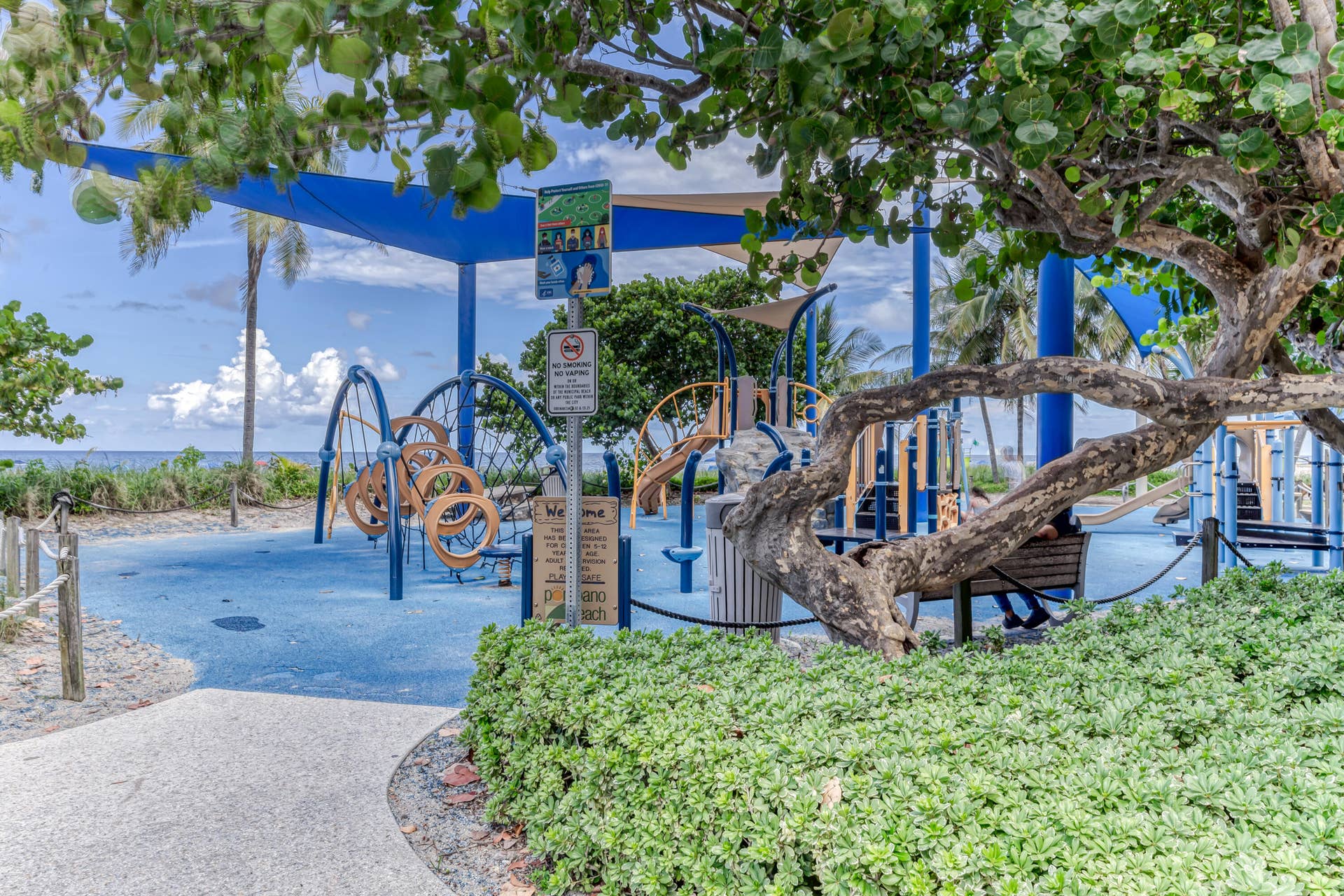 3224 NE 4th Street, Pompano Beach, FL 33062 Outdoor recreational area featuring a blue soft-surface ground, playground equipment, and shade structures