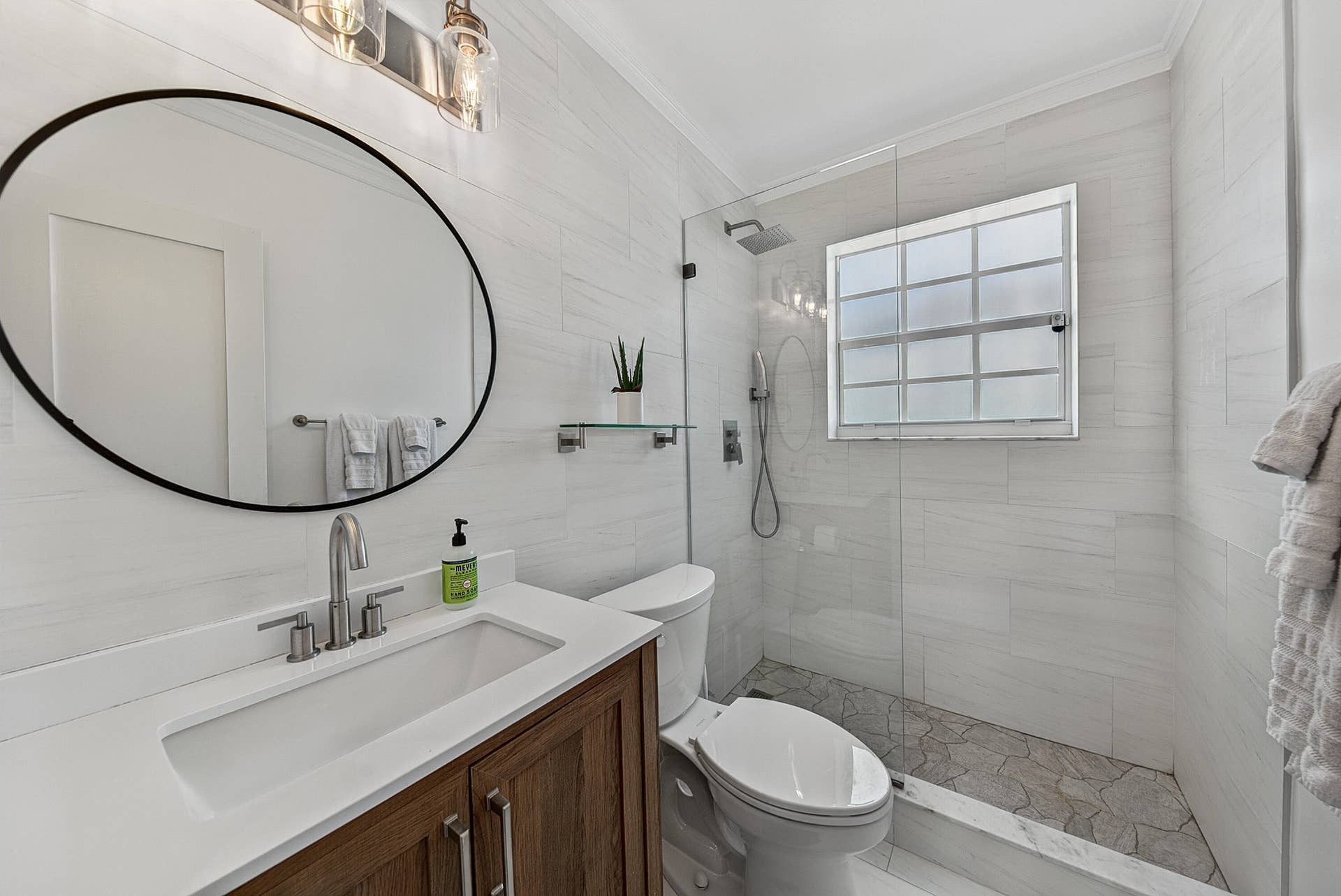 Floating vanity with wood-finish cabinetry, white countertop, and integrated rectangular sink