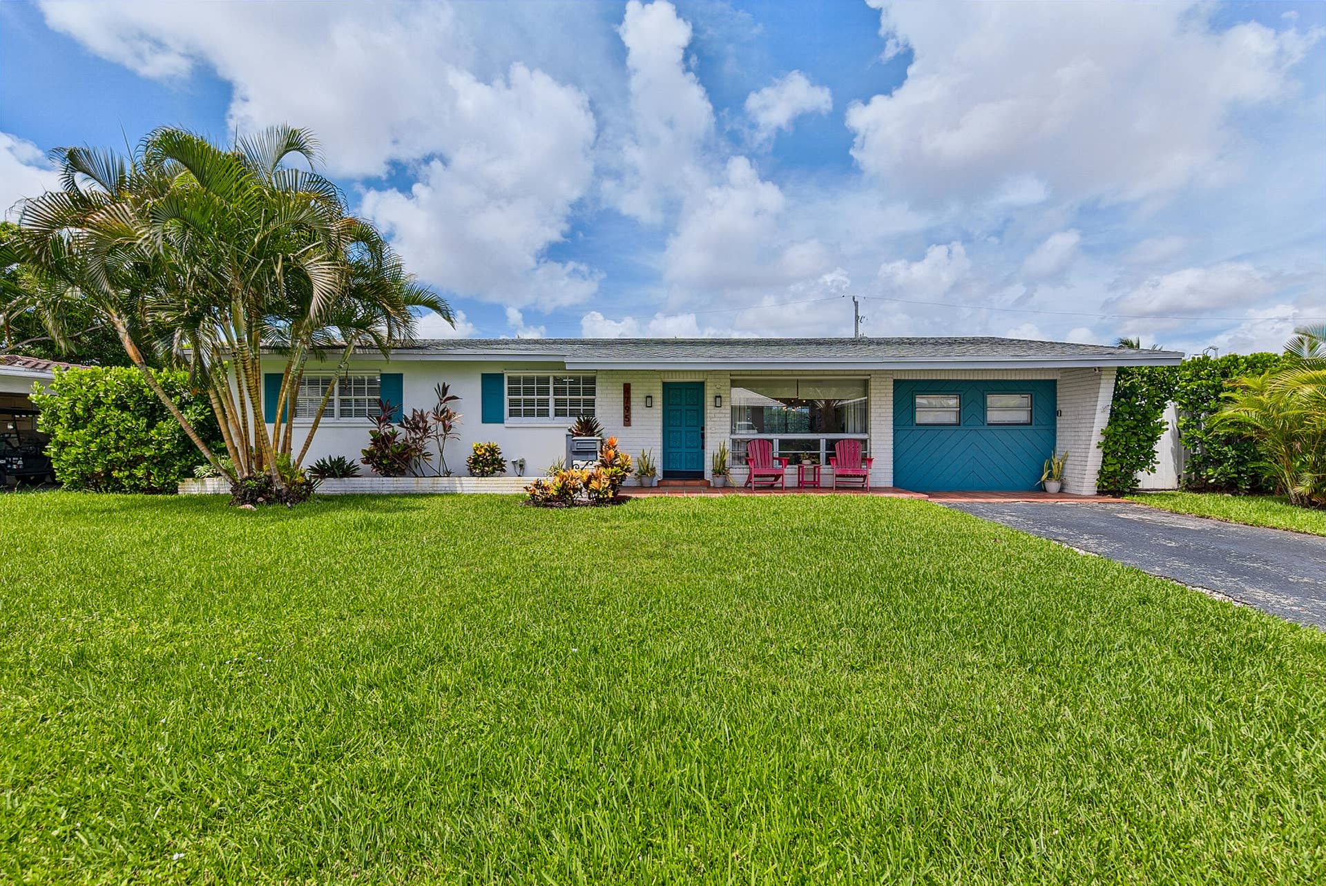 Single-story residence with a light-colored exterior and a vibrant blue front door