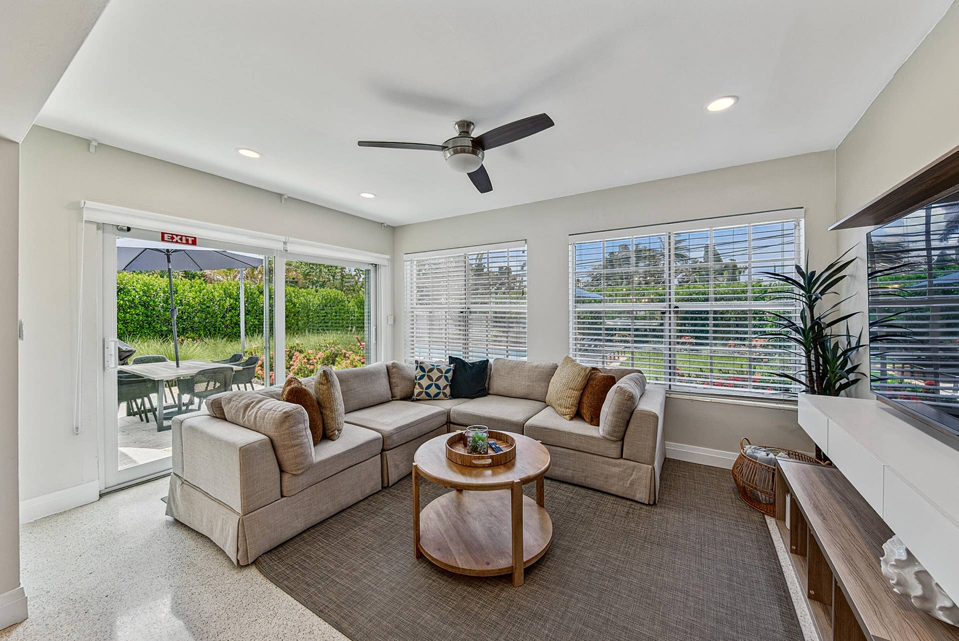 Bright, open living room anchored by a sectional seating arrangement and round wood-top cocktail table