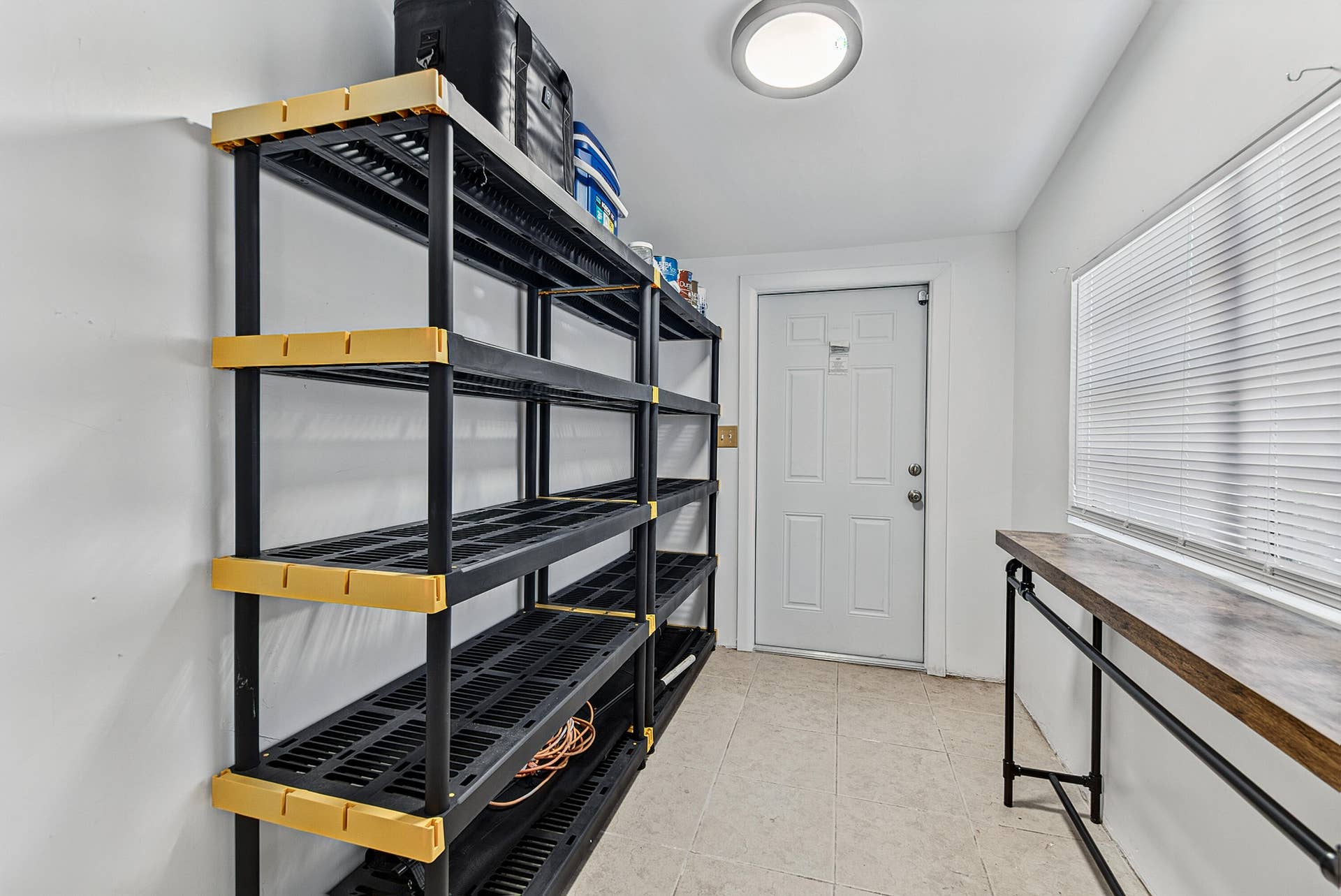 Storage area featuring built-in shelving, a panel door, a large window, a light fixture
