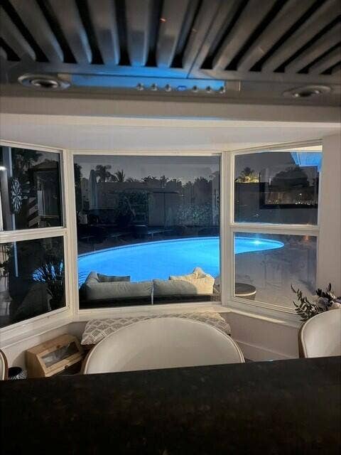 1201 SW 25TH Avenue, Boynton Beach, FL 33426 Kitchen Bay window creates a stunning nighttime view of the beautiful illuminated pool and outdoor living area.