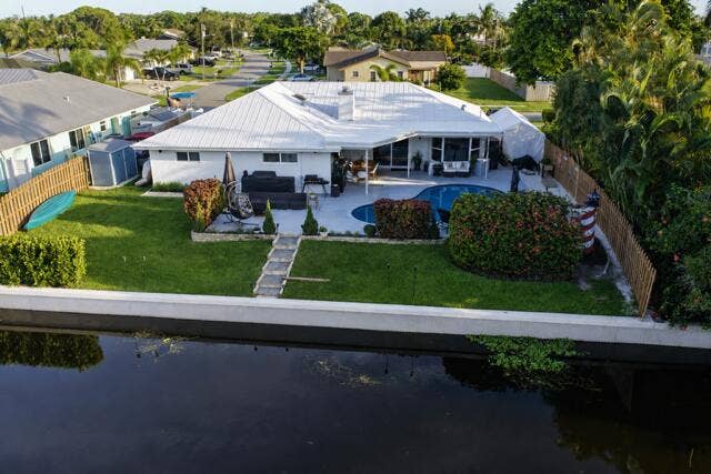 1201 SW 25TH Avenue, Boynton Beach, FL 33426 A stunning aerial view showcases this waterfront property with a spacious backyard, private pool, covered patio, and direct frontage along the navigable canal. Its beautiful landscaped with a concrete seawall completing this waterfront retreat!