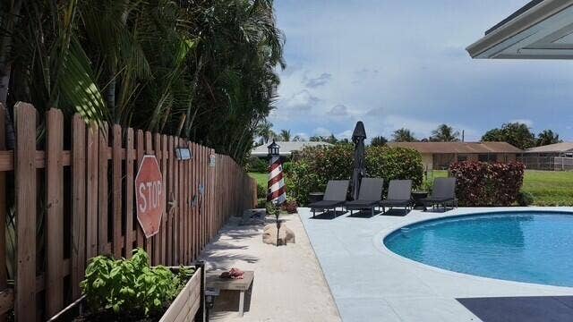 1201 SW 25TH Avenue, Boynton Beach, FL 33426 This resort-style pool area brings a touch of the beach home with its sandy retreat, tropical landscaping, and inviting lounger space. It creates a private coastal-inspired oasis right in your own backyard.