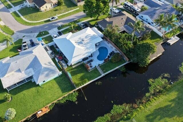 1201 SW 25TH Avenue, Boynton Beach, FL 33426 This stunning aerial view showcases the home's prime waterfront setting within a peaceful canal-front neighborhood. The private pool, lush landscaping, and expansive canal views capture the essence of relaxed South Florida living.