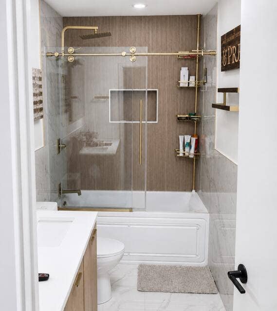 1201 SW 25TH Avenue, Boynton Beach, FL 33426 Beautifully remodeled bathroom featuring warm neutral relaxing tones, double sinks, a luxurious Jacuzzi style tub, and a sleek glass enclosed shower.