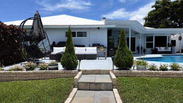 1201 SW 25TH Avenue, Boynton Beach, FL 33426 Custom Stone steps and coordinating stone walls create a beautiful transition from the lush backyard to the pool and spacious outdoor living area.