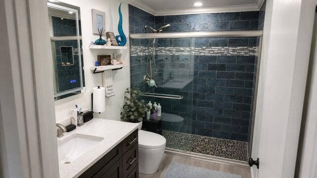 1201 SW 25TH Avenue, Boynton Beach, FL 33426 This beautiful renovated primary bathroom features a striking walk-in shower with rich color tile work, pebble- stone flooring, smart toilet with heated seat, and sleek modern finishes.