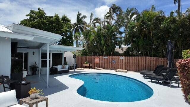 1201 SW 25TH Avenue, Boynton Beach, FL 33426 Enjoy your true Florida outdoor living with a sparkling pool, beach area, generous gathering space, and relaxing canal water views.