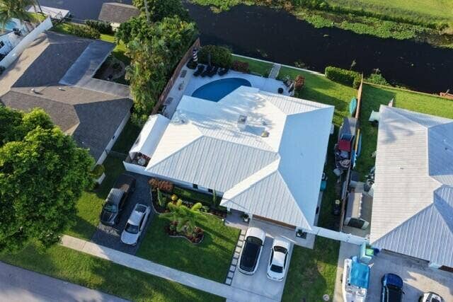 1201 SW 25TH Avenue, Boynton Beach, FL 33426 This impressive aerial view showcases the home's beautifully landscaped curb appeal, spacious lot, and inviting entrance. From above the properties prime canal-front setting, and private pool.