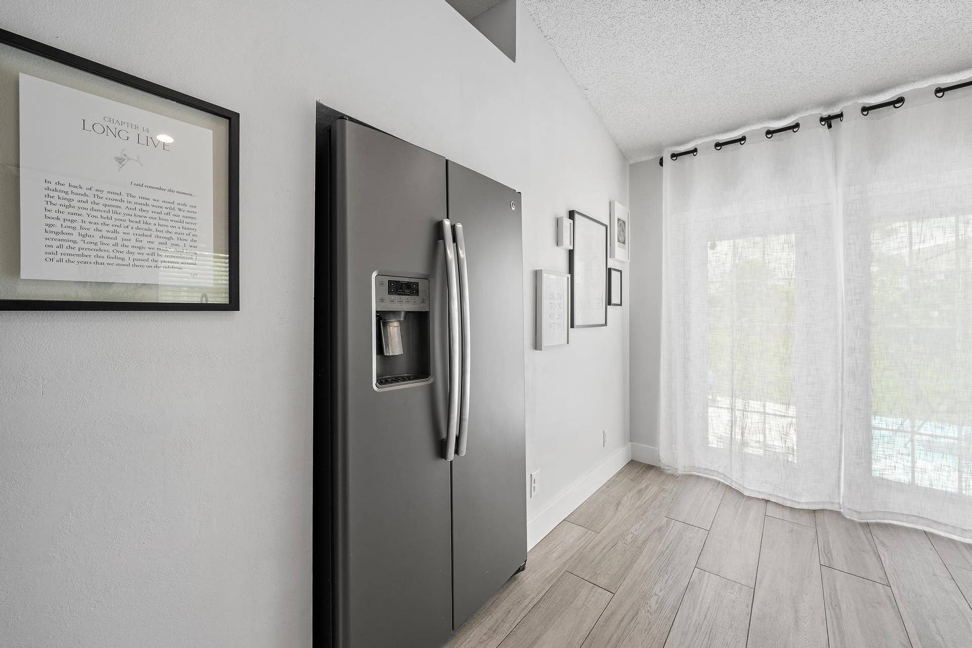 Stainless steel side-by-side refrigerator, vaulted ceiling, wood-finish flooring, and French doors