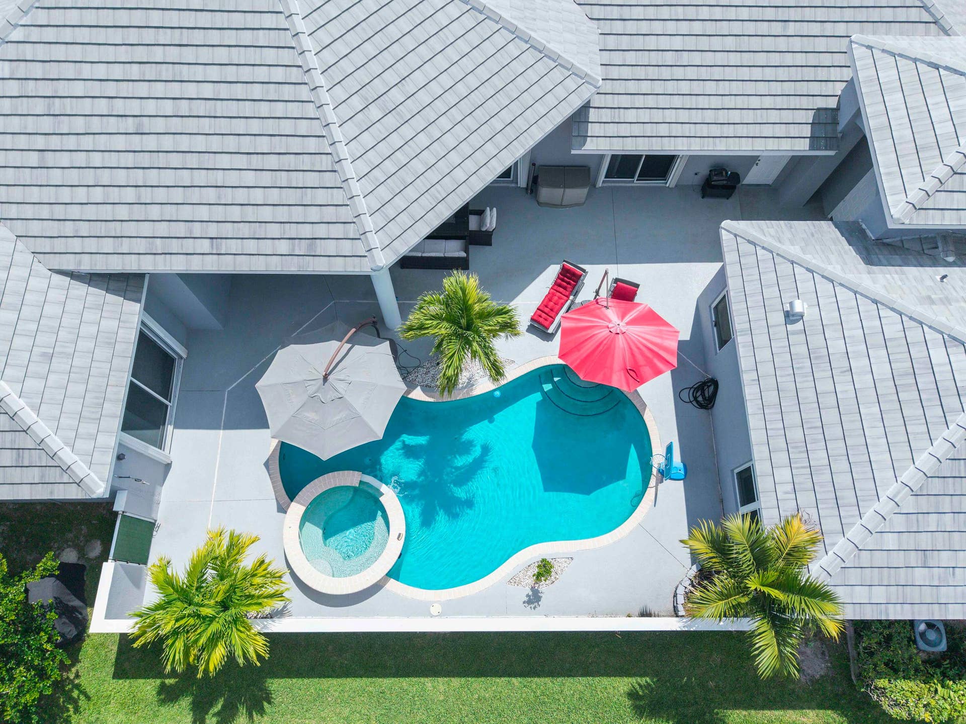 4862 Kensington Circle, Coral Springs, FL 33076 Freeform swimming pool with spa overflowing into pool. Secluded in a private courtyard with mature palm trees and resort feel.