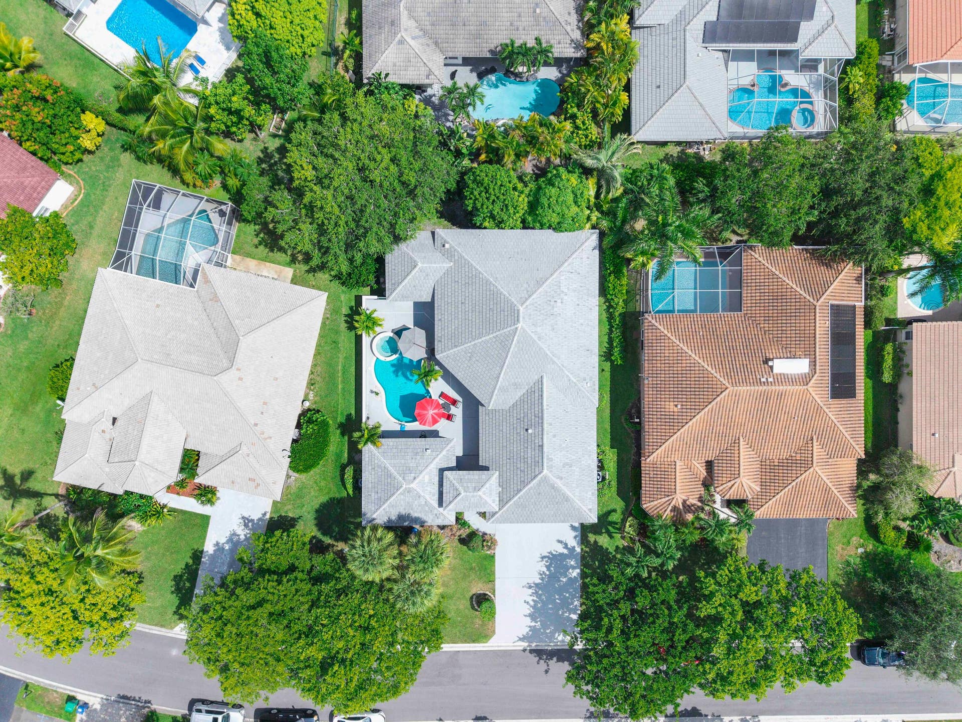 4862 Kensington Circle, Coral Springs, FL 33076 Property featuring a multi-gabled roofline, mature trees, and a private driveway
