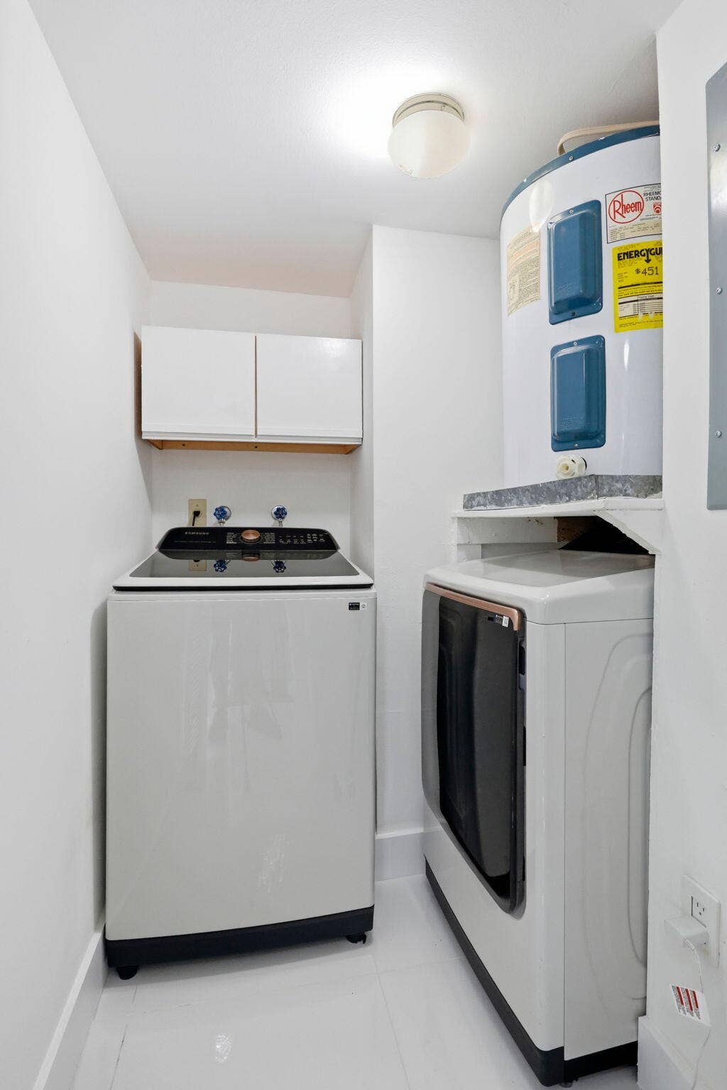 1222 Hillsboro Mile, #15, Hillsboro Beach, FL 33062 Dedicated utility area with a top-load washing machine, front-load dryer, and overhead cabinetry