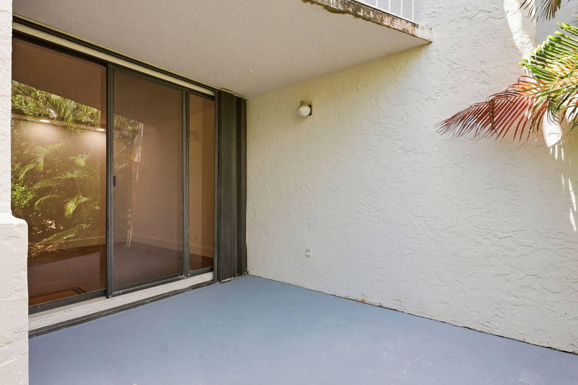 1222 Hillsboro Mile, #15, Hillsboro Beach, FL 33062 Sliding glass doors with screen, textured exterior wall, exterior wall light fixture, and concrete patio