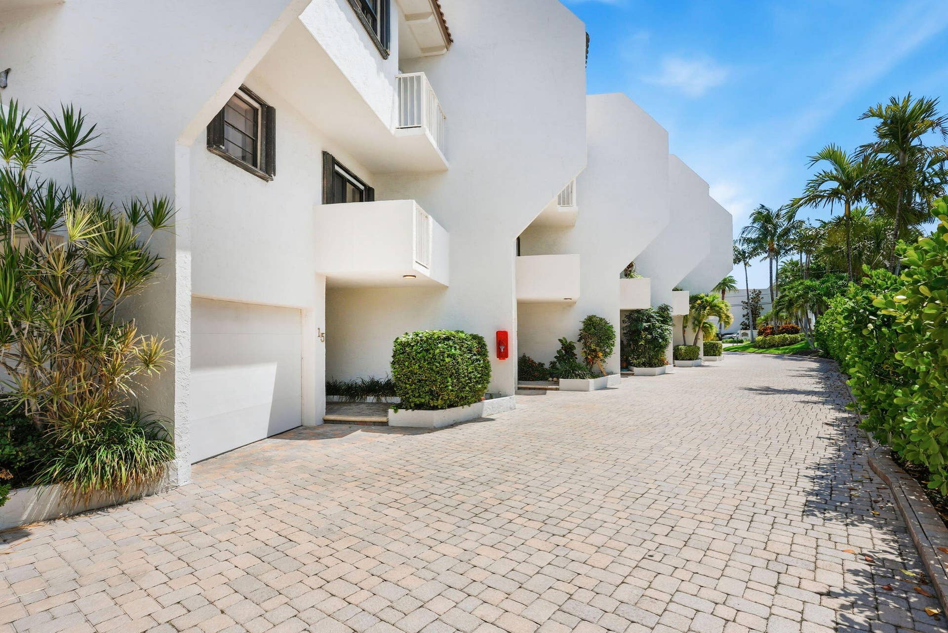 1222 Hillsboro Mile, #15, Hillsboro Beach, FL 33062 White stucco exterior with multiple balconies, private garages, and a paver driveway