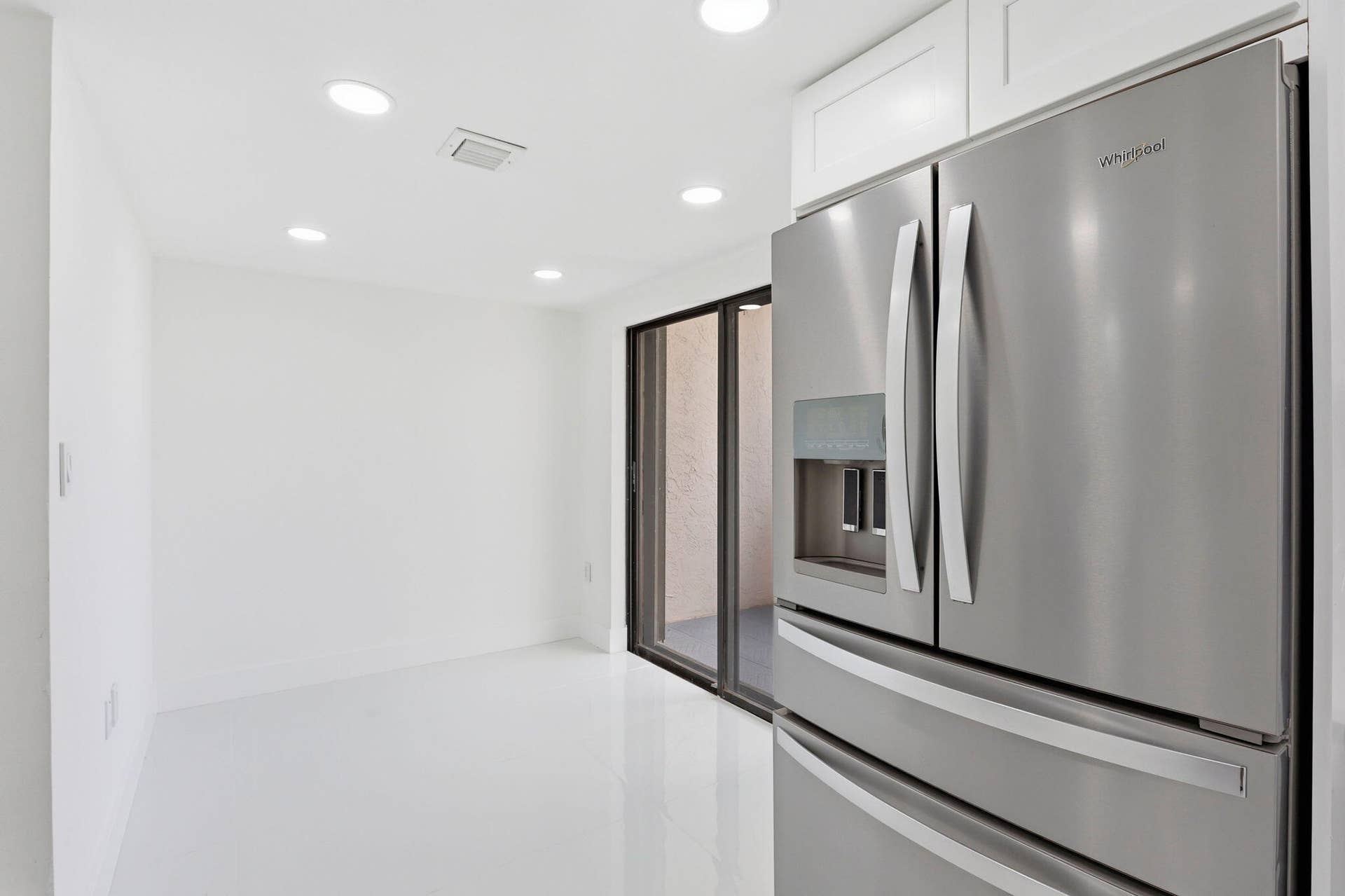 1222 Hillsboro Mile, #15, Hillsboro Beach, FL 33062 Stainless steel French door refrigerator, white cabinetry, recessed lighting, white flooring, and sliding glass door