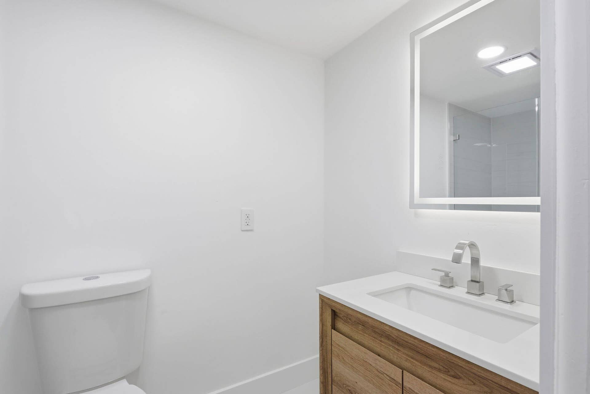 Wood-finish vanity with an integrated sink and light-colored countertop