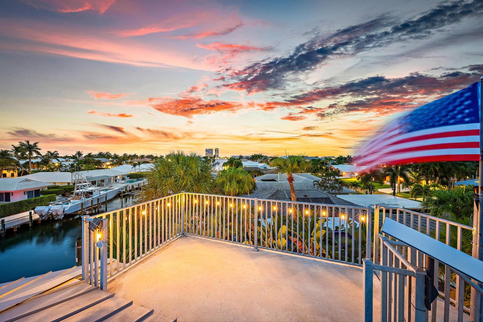 Spacious rooftop patio featuring string lighting, aluminum railings, and canal access with multiple boat docks