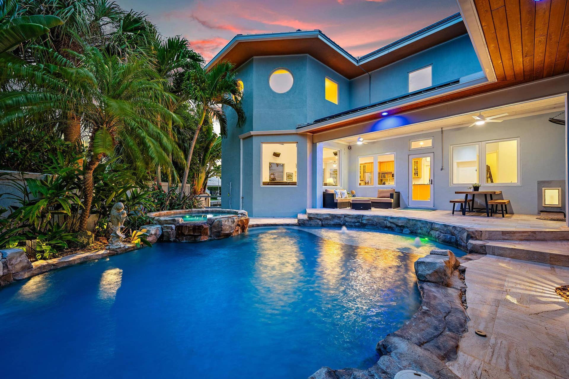 Expansive outdoor living area featuring a large swimming pool, integrated hot tub, and a spacious covered patio