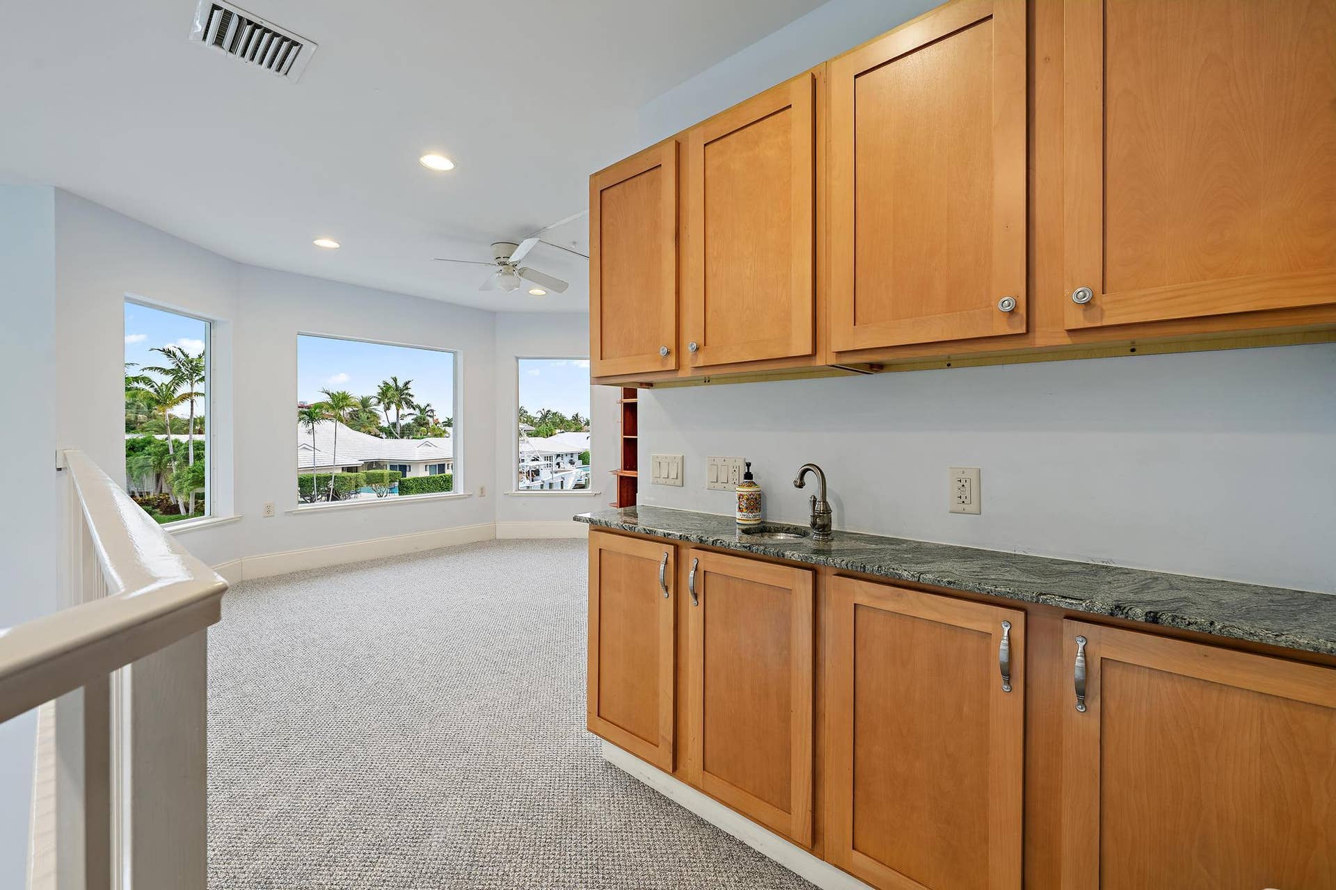 Wet bar with natural wood cabinetry and a stone countertop
