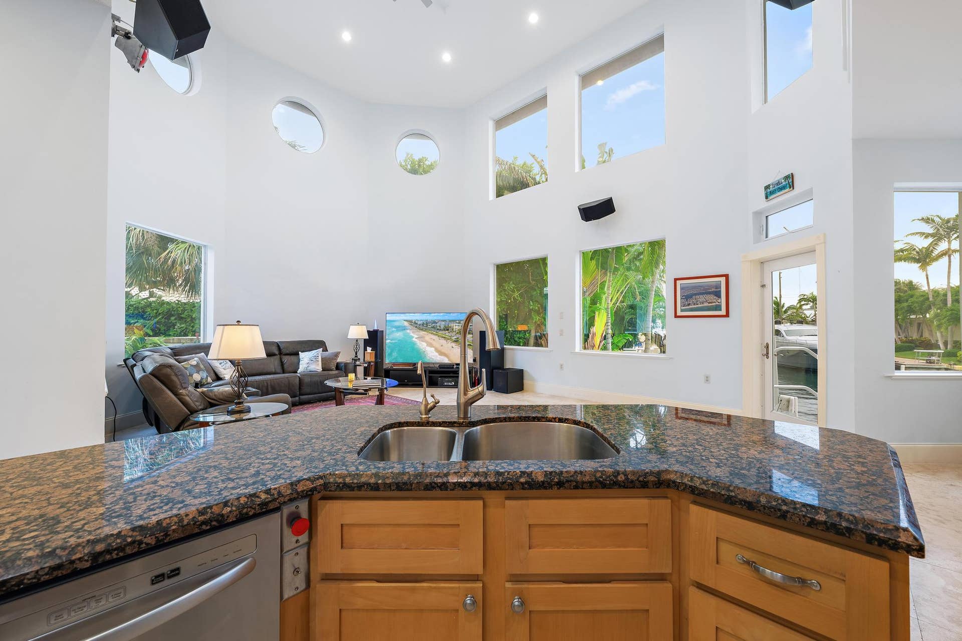Kitchen island with a double basin sink, granite countertop, and wood-finish cabinetry