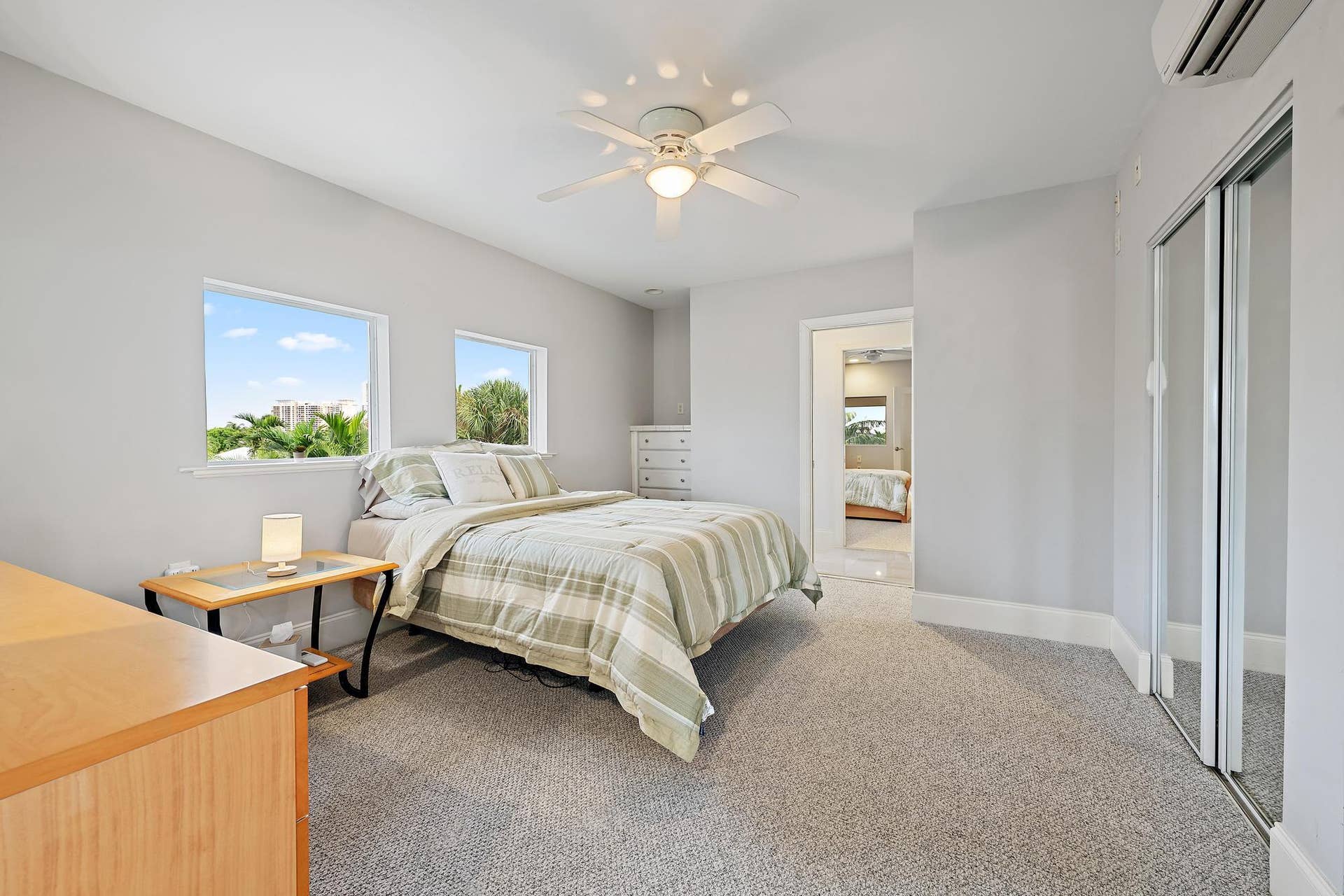 Recessed windows, ceiling fan, carpet flooring, mirrored closet doors, and a wall-mounted air conditioning unit