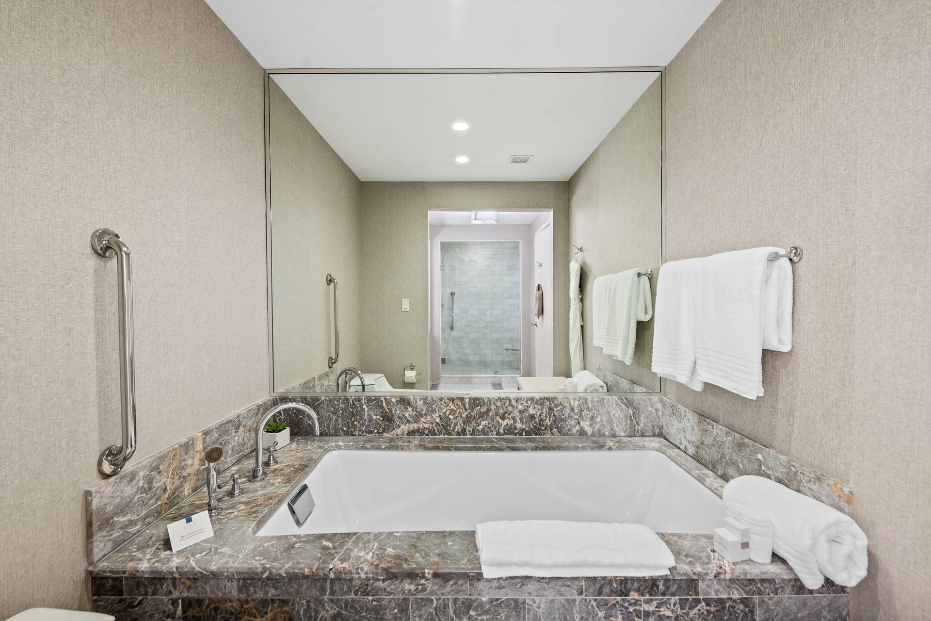 Recessed bathtub with stone surround and deck-mounted faucet