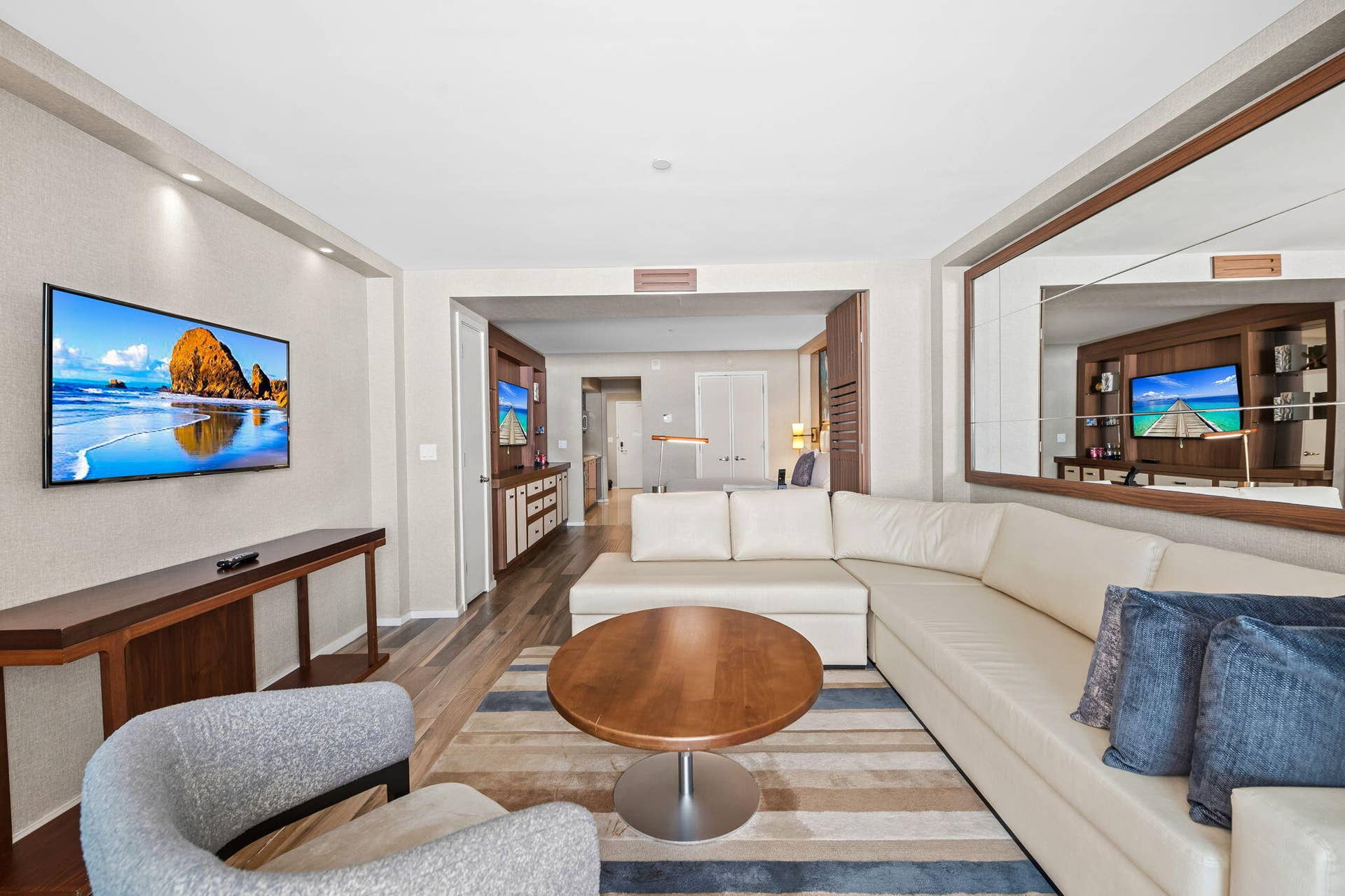Wood-finish flooring, recessed ceiling lighting, built-in display shelving, and an expansive wall-mounted mirror