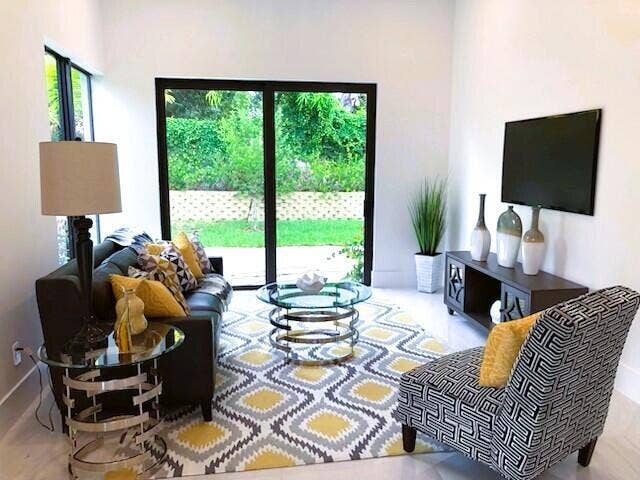 2517 Oceanview Avenue E, Delray Beach, Delray Beach, FL 33444 Spacious living area featuring large sliding glass doors, light-toned flooring, and high ceilings