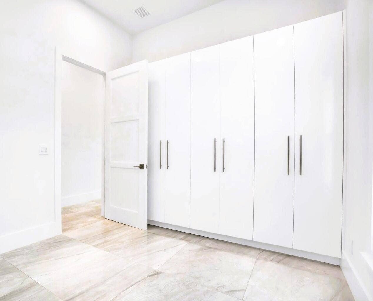 2517 Oceanview Avenue E, Delray Beach, Delray Beach, FL 33444 White built-in cabinetry with sleek hardware, light-toned tile flooring, and a contemporary panel door