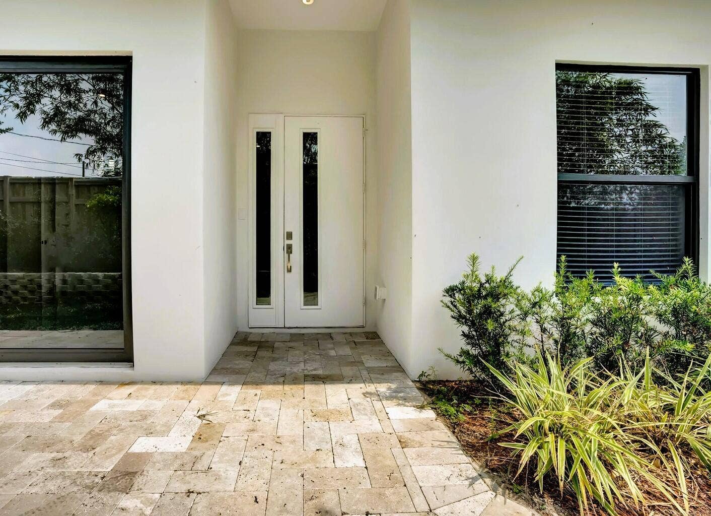 2517 Oceanview Avenue E, Delray Beach, Delray Beach, FL 33444 Double entry doors with vertical glass inserts, recessed lighting, and a stone paver entryway