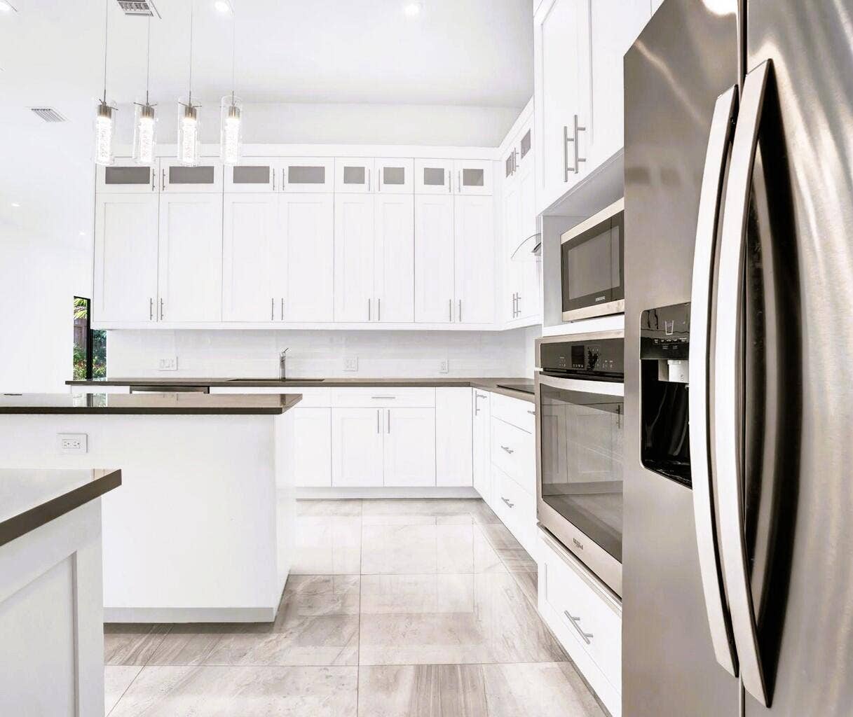 2517 Oceanview Avenue E, Delray Beach, Delray Beach, FL 33444 White cabinetry with modern hardware, stainless steel appliances, dark countertops, and tile flooring