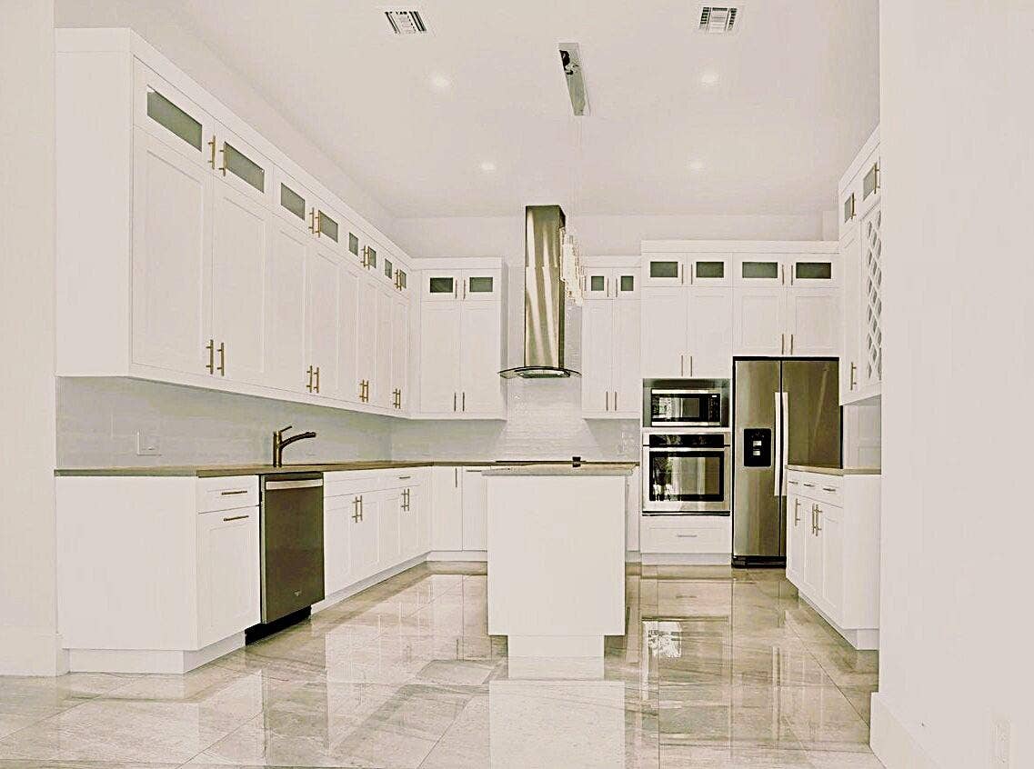 2517 Oceanview Avenue E, Delray Beach, Delray Beach, FL 33444 Modern kitchen featuring white cabinetry, stainless steel appliances, a center island, recessed lighting, and large format tile flooring