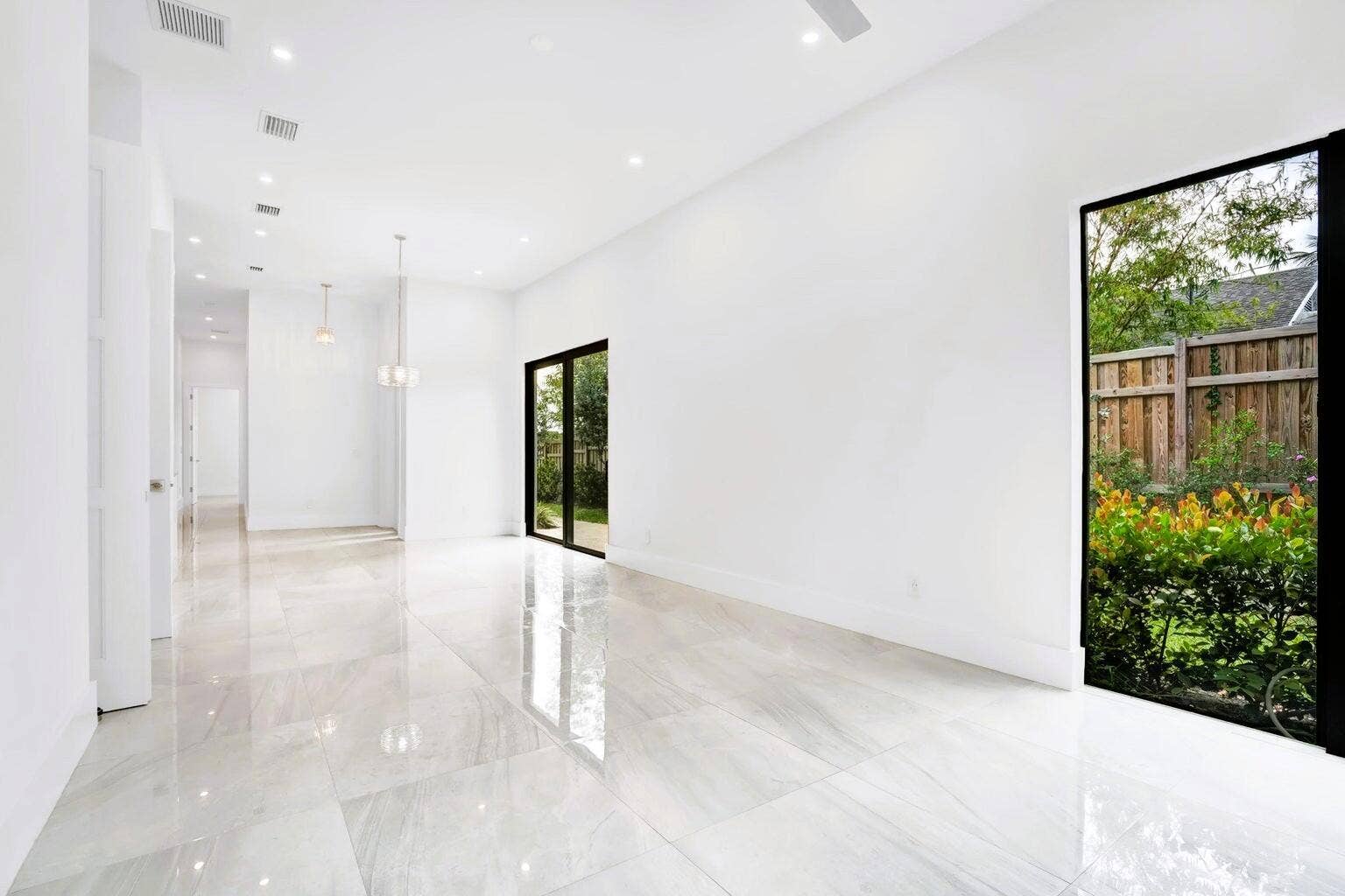 2517 Oceanview Avenue E, Delray Beach, Delray Beach, FL 33444 Spacious room featuring polished tile flooring, recessed lighting, a modern ceiling fan, and a large glass door opening to outdoor greenery