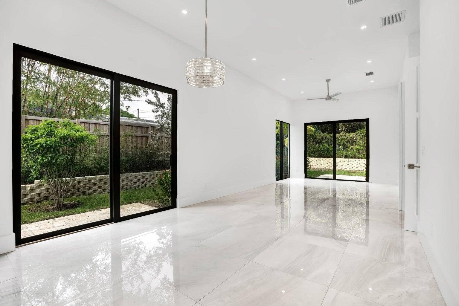2517 Oceanview Avenue E, Delray Beach, Delray Beach, FL 33444 Spacious interior featuring large format tile flooring, black-framed sliding glass doors, recessed lighting, and a modern ceiling fan