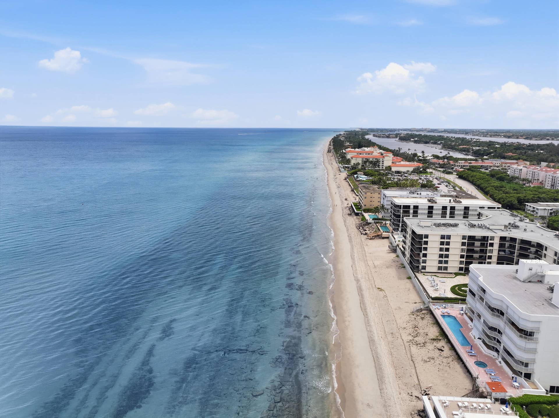3589 S Ocean Boulevard, #808, South Palm Beach, FL 33480 Panoramic coastal scene featuring expansive ocean waters and an extensive sandy beach