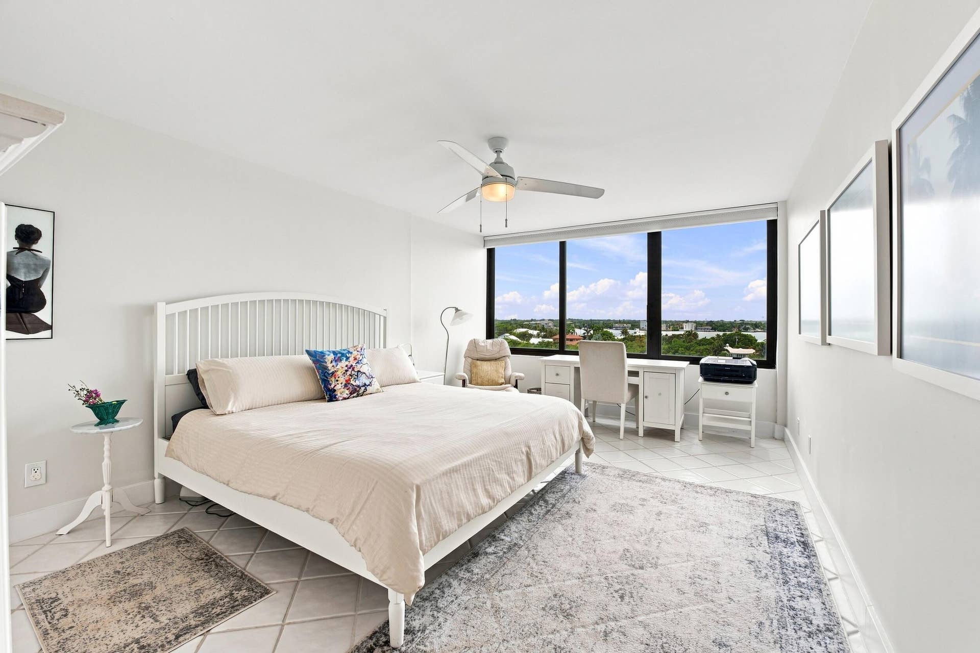 3589 S Ocean Boulevard, #808, South Palm Beach, FL 33480 Expansive window wall with a landscape backdrop, white tile flooring, ceiling fan, and white walls