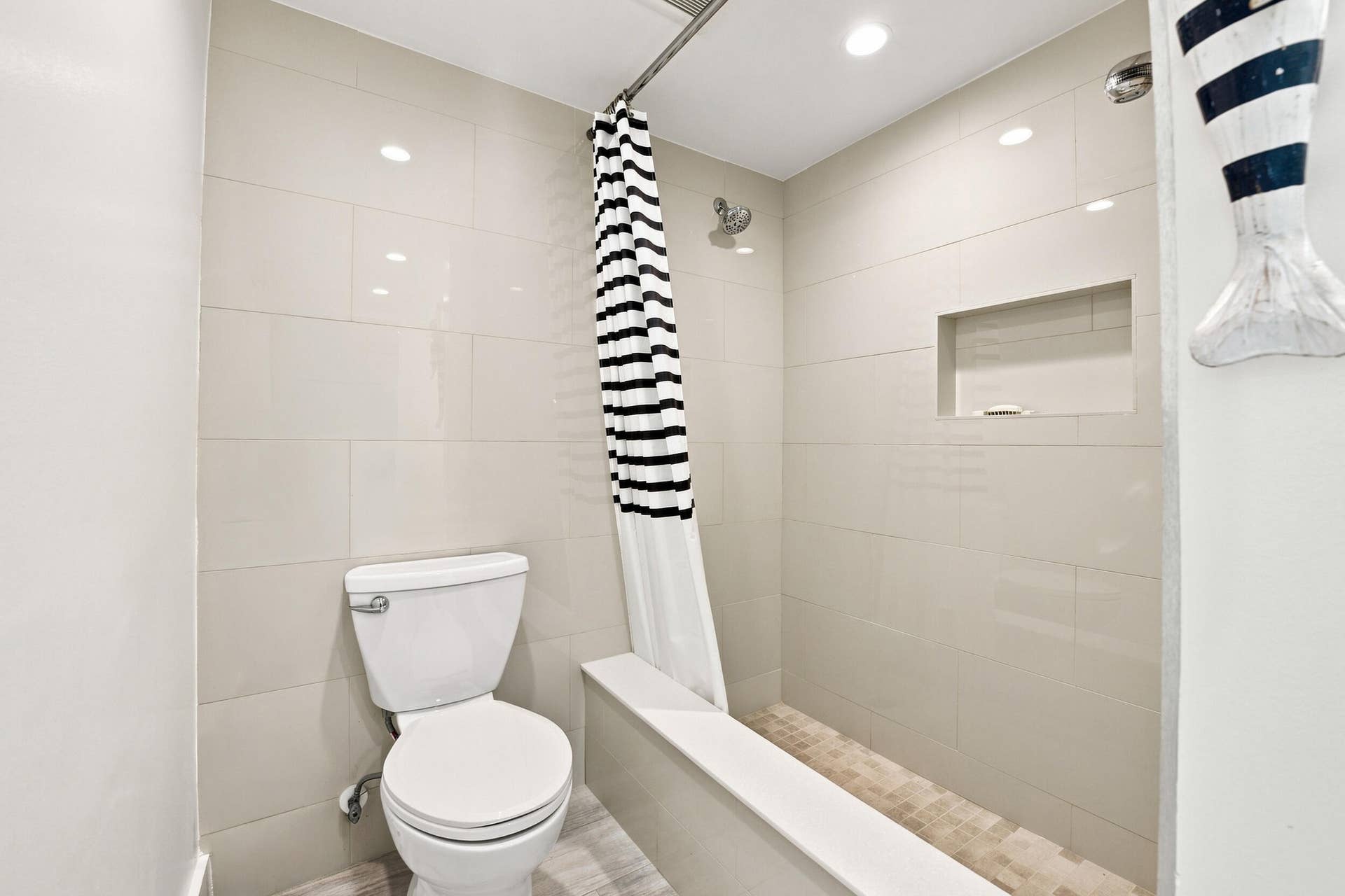 3589 S Ocean Boulevard, #808, South Palm Beach, FL 33480 Custom shower with a tub! Recessed shower niche, light-toned wall tiling, and a mosaic tiled shower floor create a cohesive bathroom design