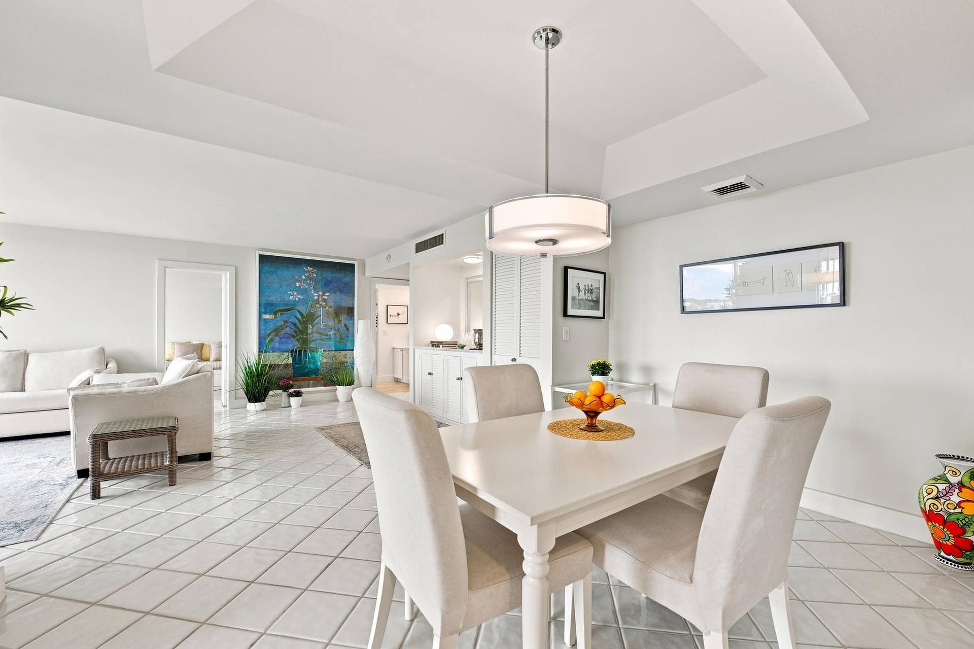3589 S Ocean Boulevard, #808, South Palm Beach, FL 33480 Open concept living and dining area featuring large format diagonal tile flooring, a tray ceiling, and a modern drum pendant light fixture