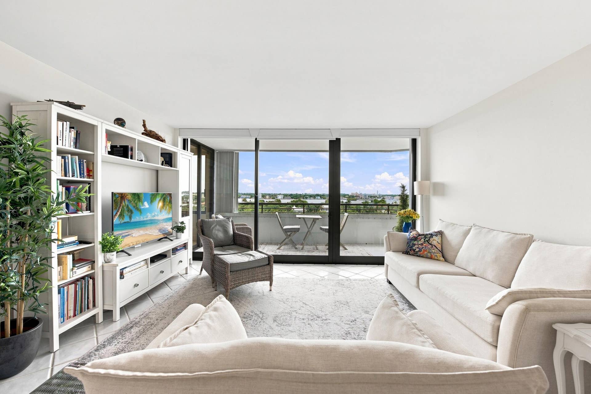 3589 S Ocean Boulevard, #808, South Palm Beach, FL 33480 Living area featuring white walls, light-colored flooring, and direct access to a balcony through expansive glass sliders