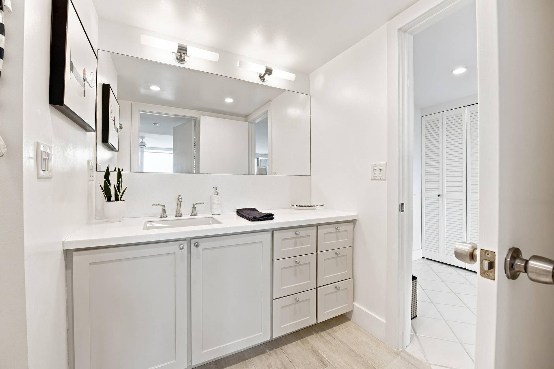 3589 S Ocean Boulevard, #808, South Palm Beach, FL 33480 Bathroom vanity featuring a single basin sink, brushed nickel faucet, and a large wall-mounted mirror