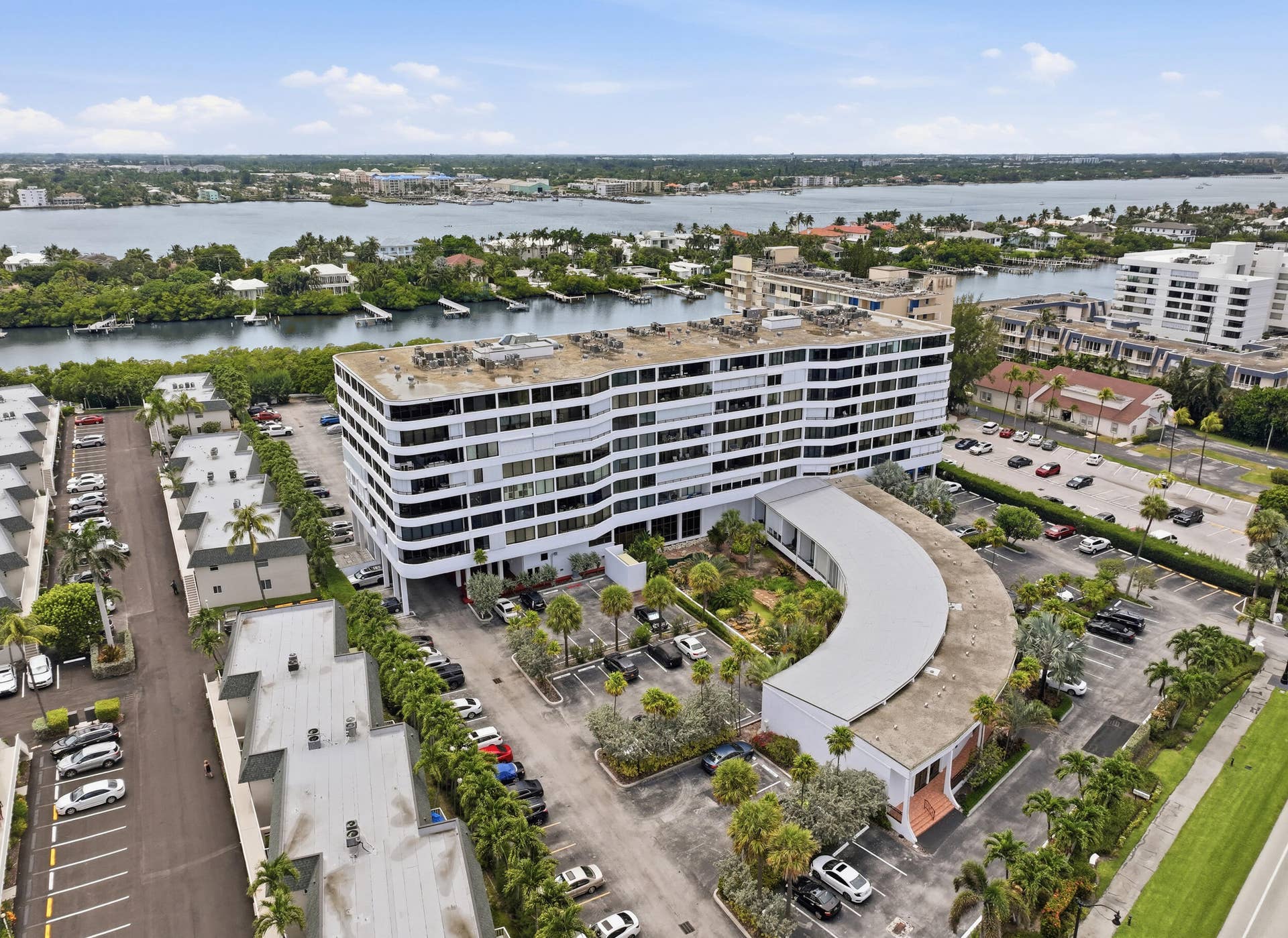3589 S Ocean Boulevard, #808, South Palm Beach, FL 33480 Modern multi-story building featuring multiple balconies, a curved architectural element, and integrated landscaping