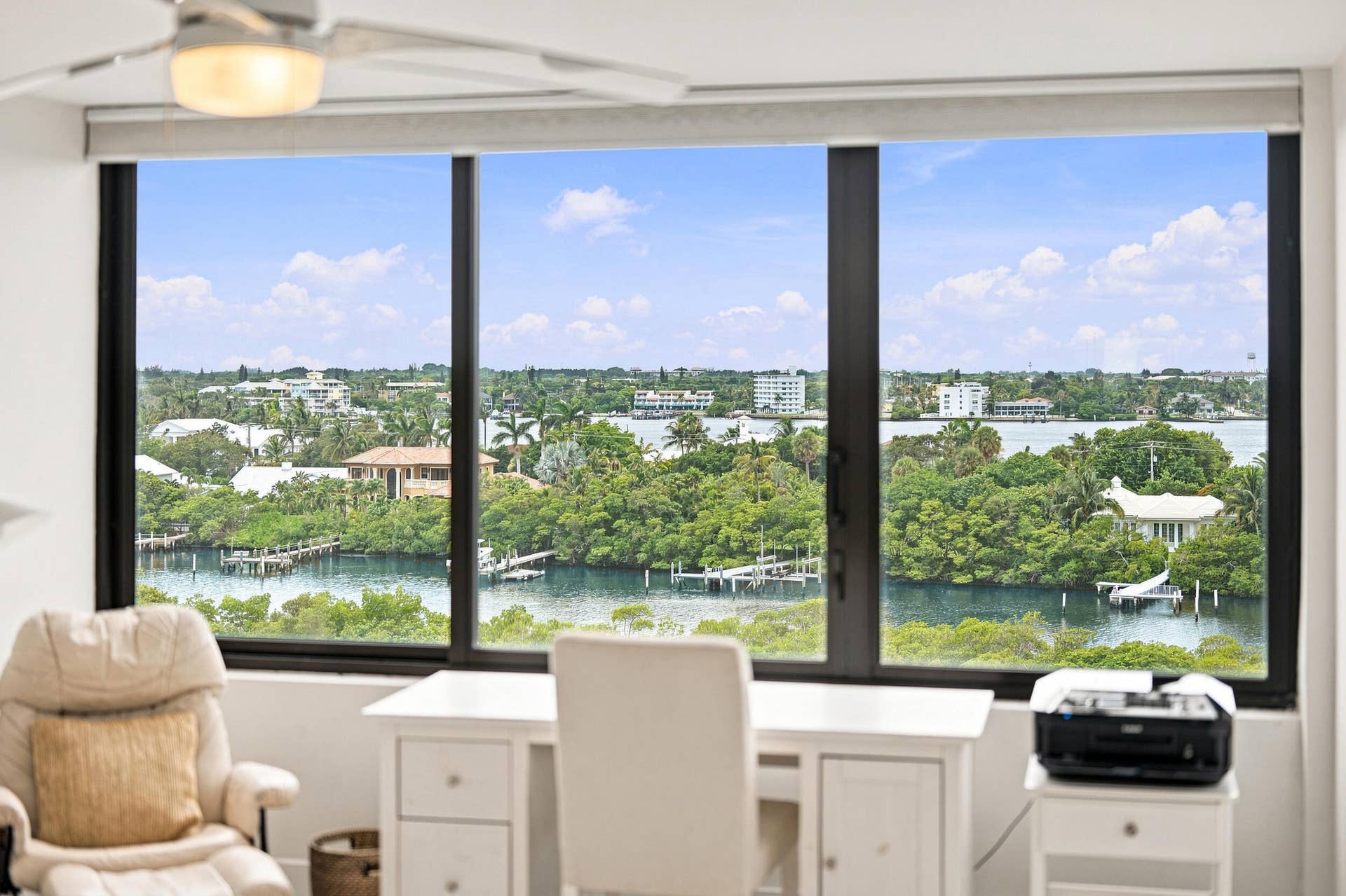 3589 S Ocean Boulevard, #808, South Palm Beach, FL 33480 Expansive windows showcasing a waterfront landscape with residential architecture and lush greenery
