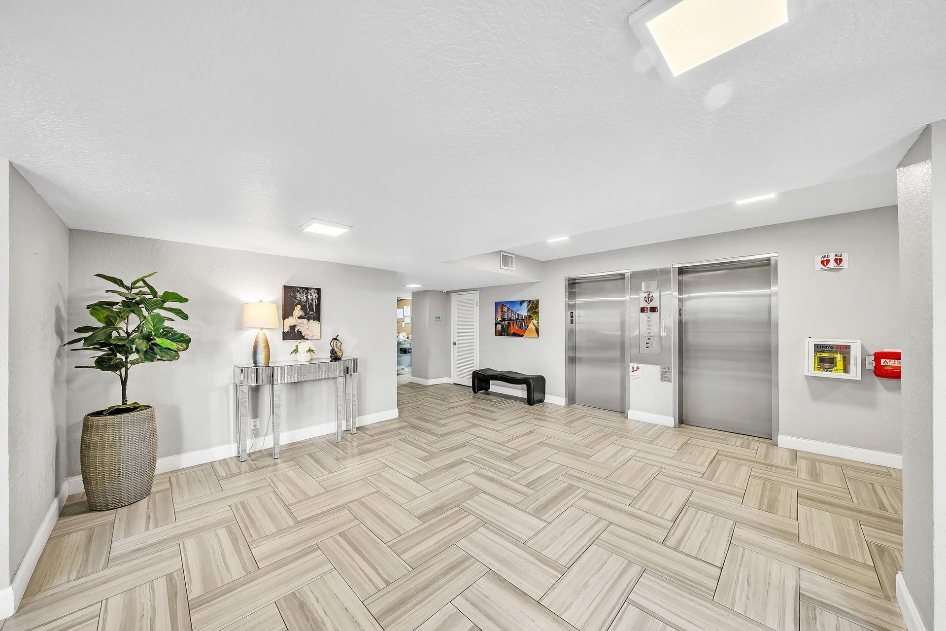 3051 NE 48TH Street, #301, Fort Lauderdale, Fort Lauderdale, FL 33308 Herringbone-patterned wood-finish flooring, recessed lighting, and dual stainless steel elevators