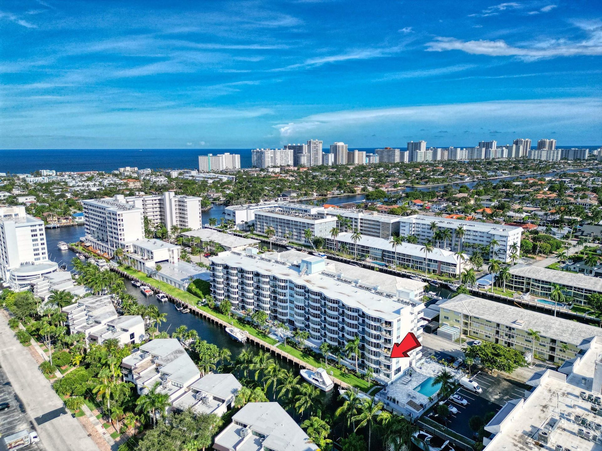 3051 NE 48TH Street, #301, Fort Lauderdale, Fort Lauderdale, FL 33308 Multistory residential building featuring multiple balconies, a ground-level pool, and surrounding waterways
