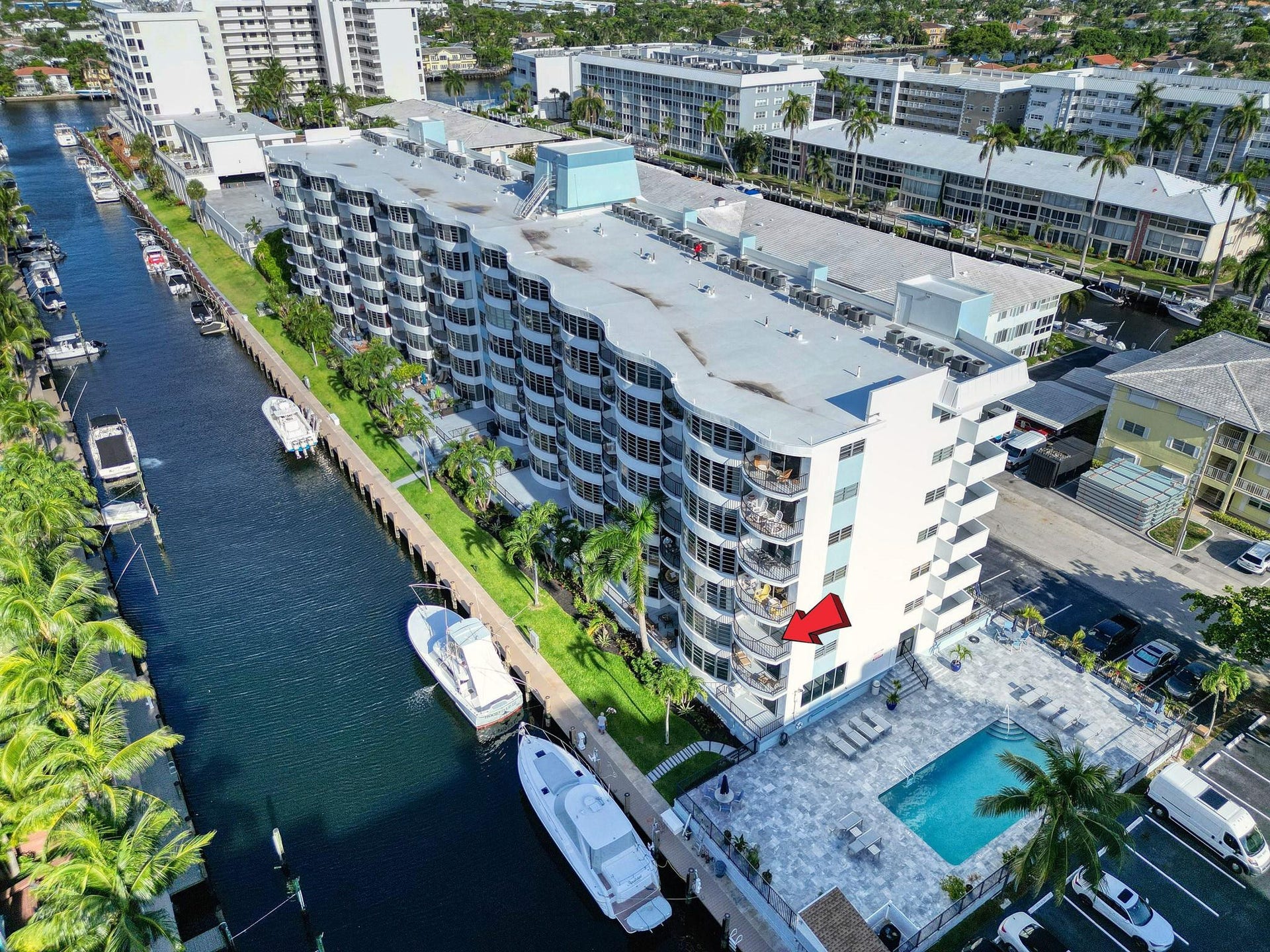 3051 NE 48TH Street, #301, Fort Lauderdale, Fort Lauderdale, FL 33308 Waterfront property featuring a multi-story building with multiple balconies, a swimming pool, and dedicated parking
